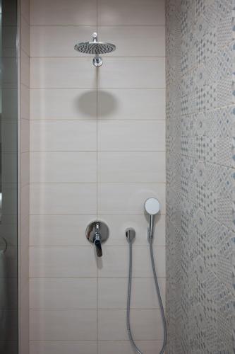 a shower with a shower head in a bathroom at Hana - Apartments in Ljubljana