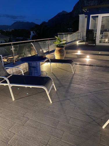 a couple of chairs sitting on a deck at night at B&B Torre Pozzillo in Cinisi