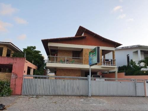 a house with a fence in front of it at Pousada Jasmine in João Pessoa