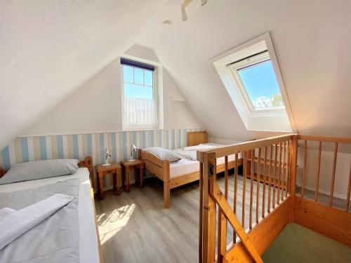 ティンメンドルフにあるEndearing Apartment in Insel Poel with Saunaの屋根裏のベッドルーム(ベッド1台、窓付)