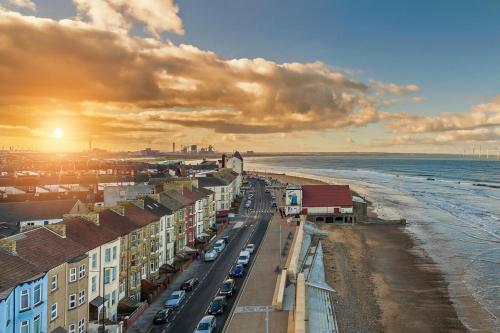 Una vista de una playa con edificios y el océano. en The Dunes, en Redcar