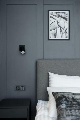 a bedroom with a bed and a picture on the wall at Apartamenty L11, Limanowskiego in Poznań