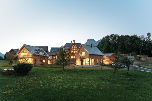 a large wooden house in a field of grass at Schmiedgut Bad Aussee in Bad Aussee