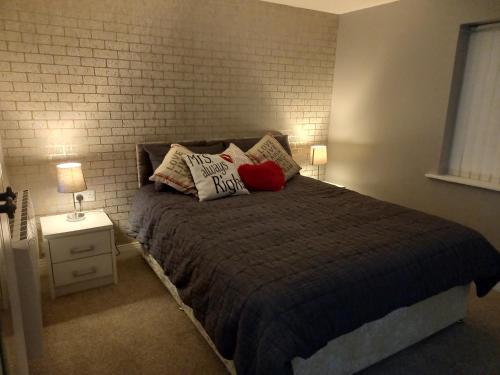 a bedroom with a bed with pillows and a brick wall at Login house A in Derry Londonderry