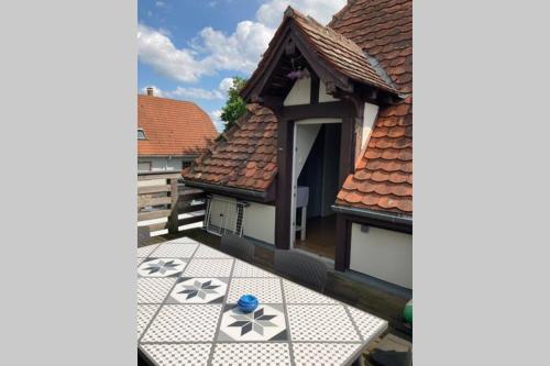 a house with a tile floor and a roof at Le Clos d’Azel - Le gîte du cocher avec piscine in Flexbourg