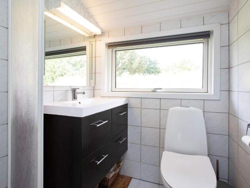 ブラーバンドにあるHoliday home Blåvandのバスルーム(トイレ、洗面台付)、窓が備わります。