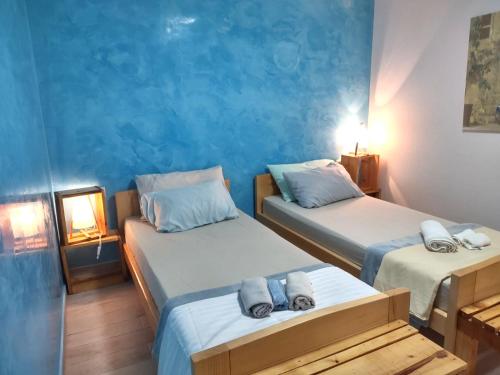 2 camas en una habitación con paredes azules en Stone Villa Hvar Ana and Nikola Beachfront en Jelsa