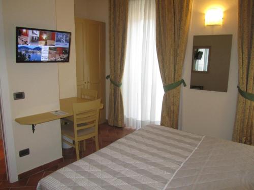 a bedroom with a bed and a desk and a television at Hotel Borgovico in Como