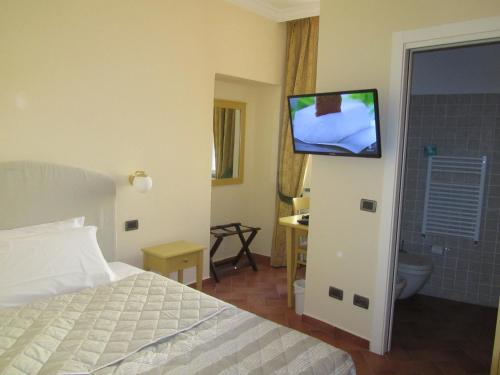 a bedroom with a bed and a tv on a wall at Hotel Borgovico in Como