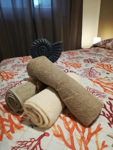 a towel animal laying on top of a bed at APPARTAMENTO CORALLO with PRIVATE GARDEN in Olbia