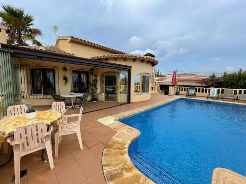 a patio with a table and chairs and a pool at Villa Alexandra Calpe in Calpe