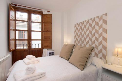 um quarto com uma cama com toalhas em Chezmoihomes Alhambra em Granada