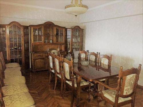 uma sala de jantar com uma mesa de madeira e cadeiras em Spacious and Cozy em Tashkent