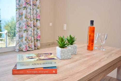a wooden table with books and a bottle of alcohol at Casa Tramonto Beach View Agios Gordios Corfu in Agios Gordios