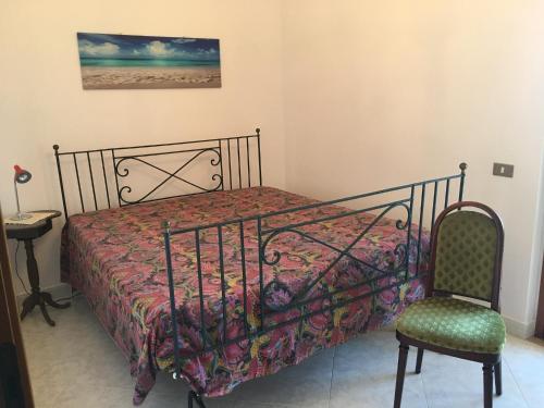 a bedroom with a bed and a chair and a picture at Casa Mare di Ponente in Erice