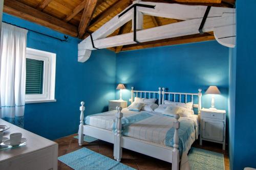 a blue bedroom with a white bed and two lamps at Domus Corallia-Luxury Rooms in Porto Rotondo