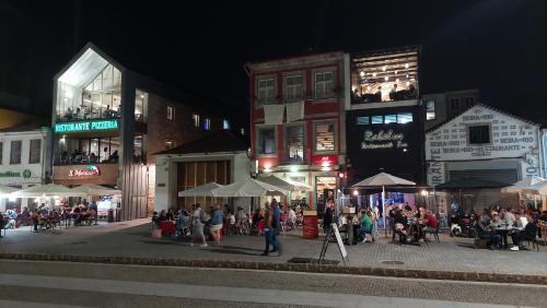 a group of people walking down a street at night at Vitoria Douro in Vila Nova de Gaia