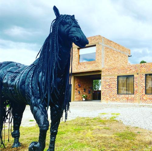 a statue of a horse in front of a building at Romántica Cabaña con vista a la ciudad, 10 min del Centro in Chiquinquirá