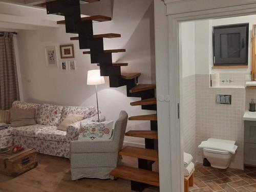 eine Wendeltreppe in einem Wohnzimmer mit einem Sofa in der Unterkunft BABIE LATO dostęp do jeziora UBLIK in Konopki Wielkie