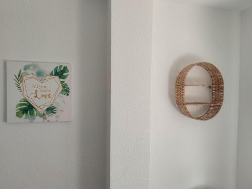 a mirror and a wreath hanging on a wall at Precioso apartamento en la playa de Bellreguard in Bellreguart