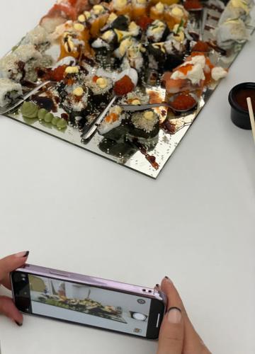 a person taking a picture of a plate of food at Hotel AVENUE in Ravda