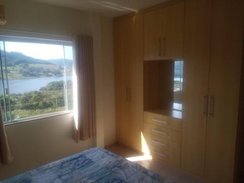 a bedroom with a bed and a window with a view at Apartamento em Marcelino Ramos ao lado das Termas in Belém Velho