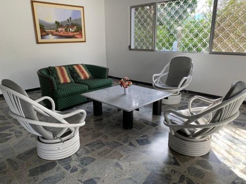 a living room with chairs and a table and a couch at La Toscana in Chinauta