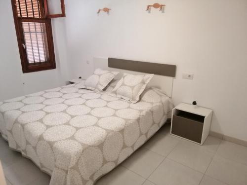 a bedroom with a large bed and a small table at Сozy apartment in Las Americas in Playa Fañabe