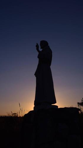 a statue of a woman holding a camera at sunset at Pousada Pato Mergulhão in Vargem Bonita