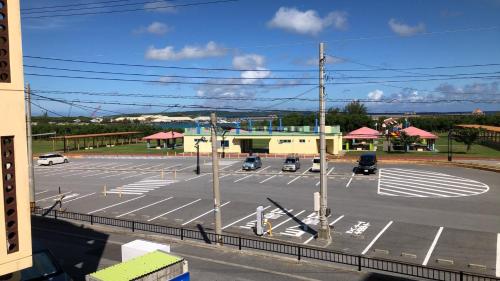 ein leerer Parkplatz mit Autos, die darin geparkt sind in der Unterkunft ジンジャー in Miyako-jima