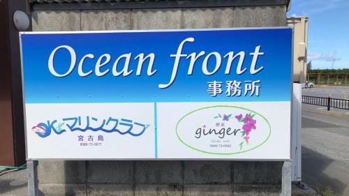 una señal para un frente oceánico a un lado de una carretera en ジンジャー en Isla Miyako