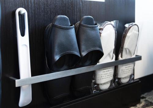 a pair of black boots and other shoes in a drawer at APA Hotel & Resort Niigata Ekimae Odori in Niigata