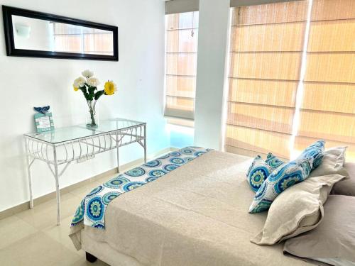 a bedroom with a bed and a table with a vase of flowers at Apartamento Edificio Bahia Fragata in San Andrés