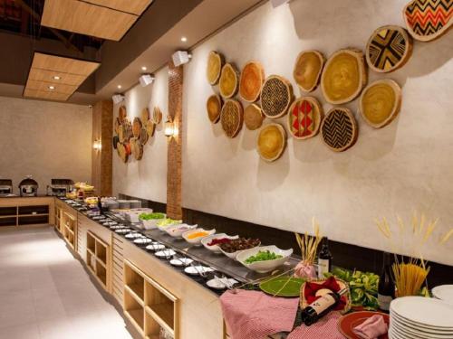 a buffet line in a restaurant with plates of food at Ondas Praia Resort in Porto Seguro