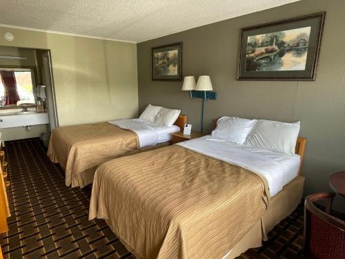 um quarto de hotel com duas camas e uma janela em Bravo Inn em Johnson City