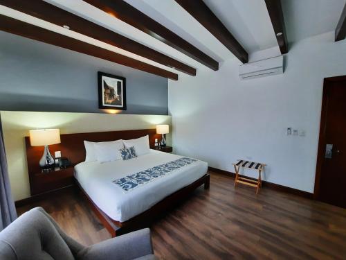 a bedroom with a large bed and a couch at Casa San Miguel Hotel Boutique y Spa in Zacatlán