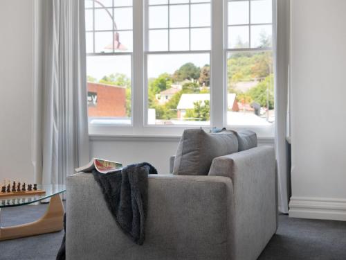 a living room with a couch and a large window at 1913 on Vincent- Centrally located apartment in Daylesford