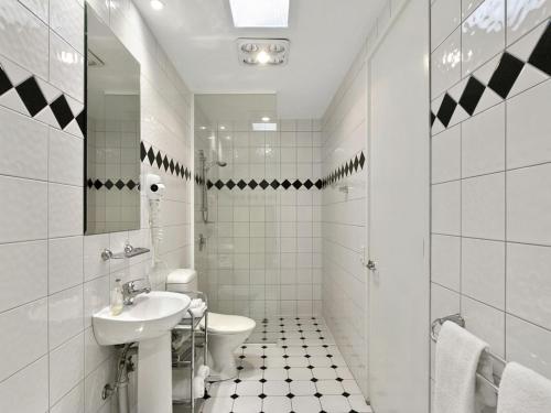 Baño blanco con lavabo y aseo en Villa Sorelle en Daylesford