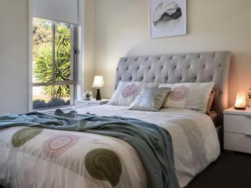 a bedroom with a large bed with a large window at Musk Vale Villa - dog friendly, 5 mins to town in Musk Vale