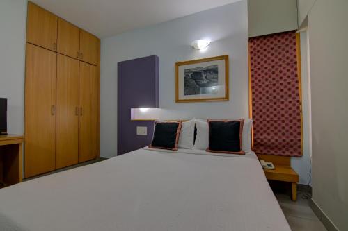 a bedroom with a large white bed in a room at Tristar Serviced Apartments in Bengaluru