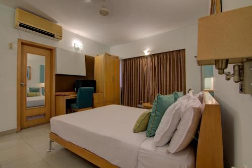 a hotel room with a bed and a desk at Tristar Serviced Apartments in Bengaluru