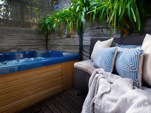 a jacuzzi tub sitting on a patio with a couch at Ravenswood- elegance and old world charm in Daylesford