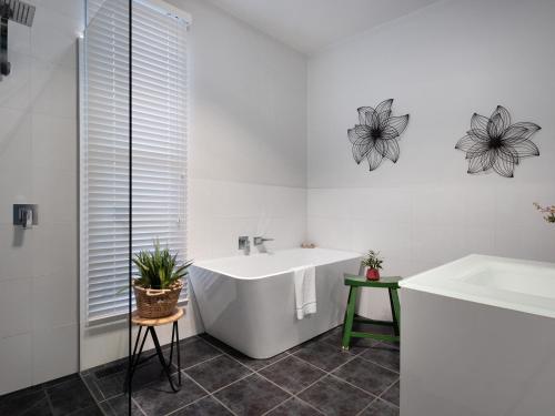 a white bathroom with a tub and a sink at Lake Como Villa in Daylesford