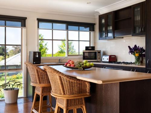 a kitchen with a table with a bowl of fruit on it at Churchills - outstanding views over Daylesford in Daylesford