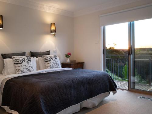 a bedroom with a bed and a large window at Churchills in Daylesford