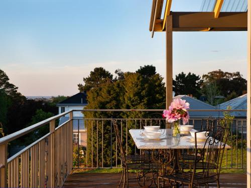 a table on a deck with a table and chairs at Churchills - outstanding views over Daylesford in Daylesford