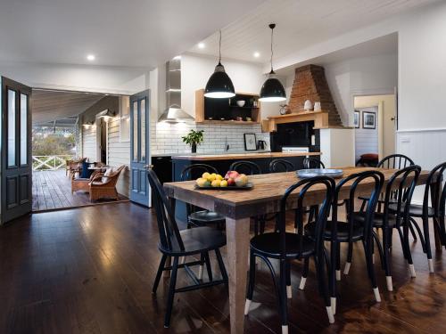 a kitchen and dining room with a wooden table and chairs at Dunroman - modern comfort, old world charm in Daylesford