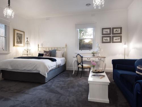 a bedroom with a bed and a blue couch at Dunroman in Daylesford