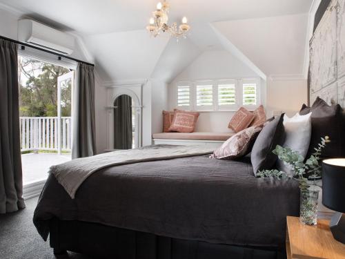 a bedroom with a large bed with a chandelier at The Orchard in Daylesford