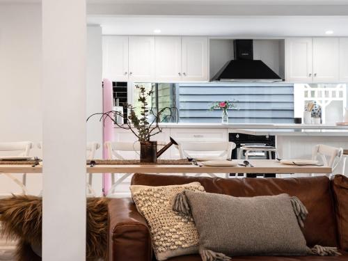 a living room with a couch and a kitchen at The Orchard in Daylesford